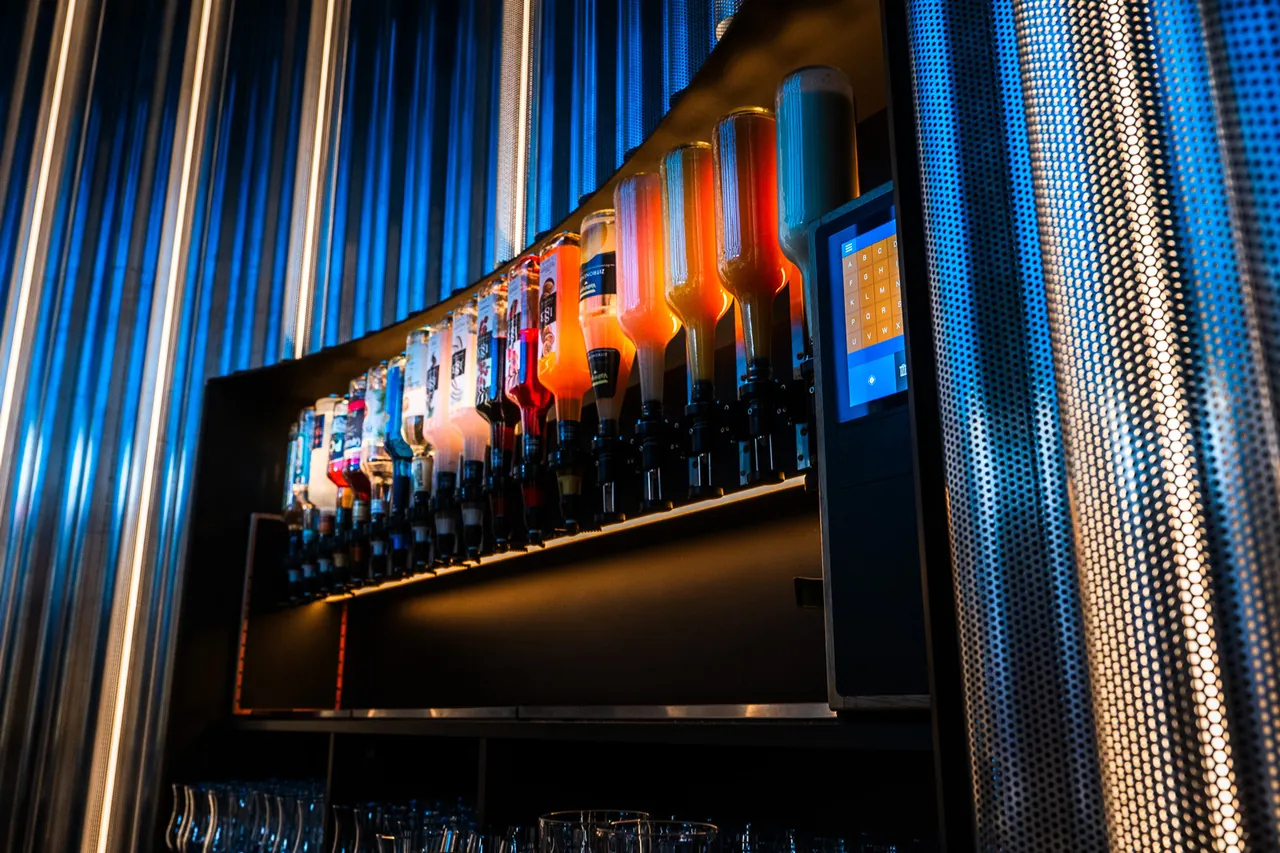 Cocktailmaschine CocktailBot mit 18 beleuchteten Flaschen und Touchscreen hinter der Theke einer Kölner Bar