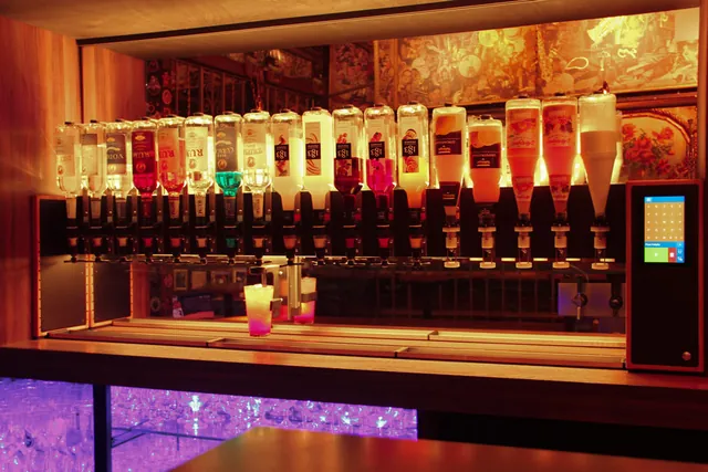 Cocktailmaschine im warmen Licht einer Kölner Kneipe, ein fertiger Cocktail steht auf dem Schlitten